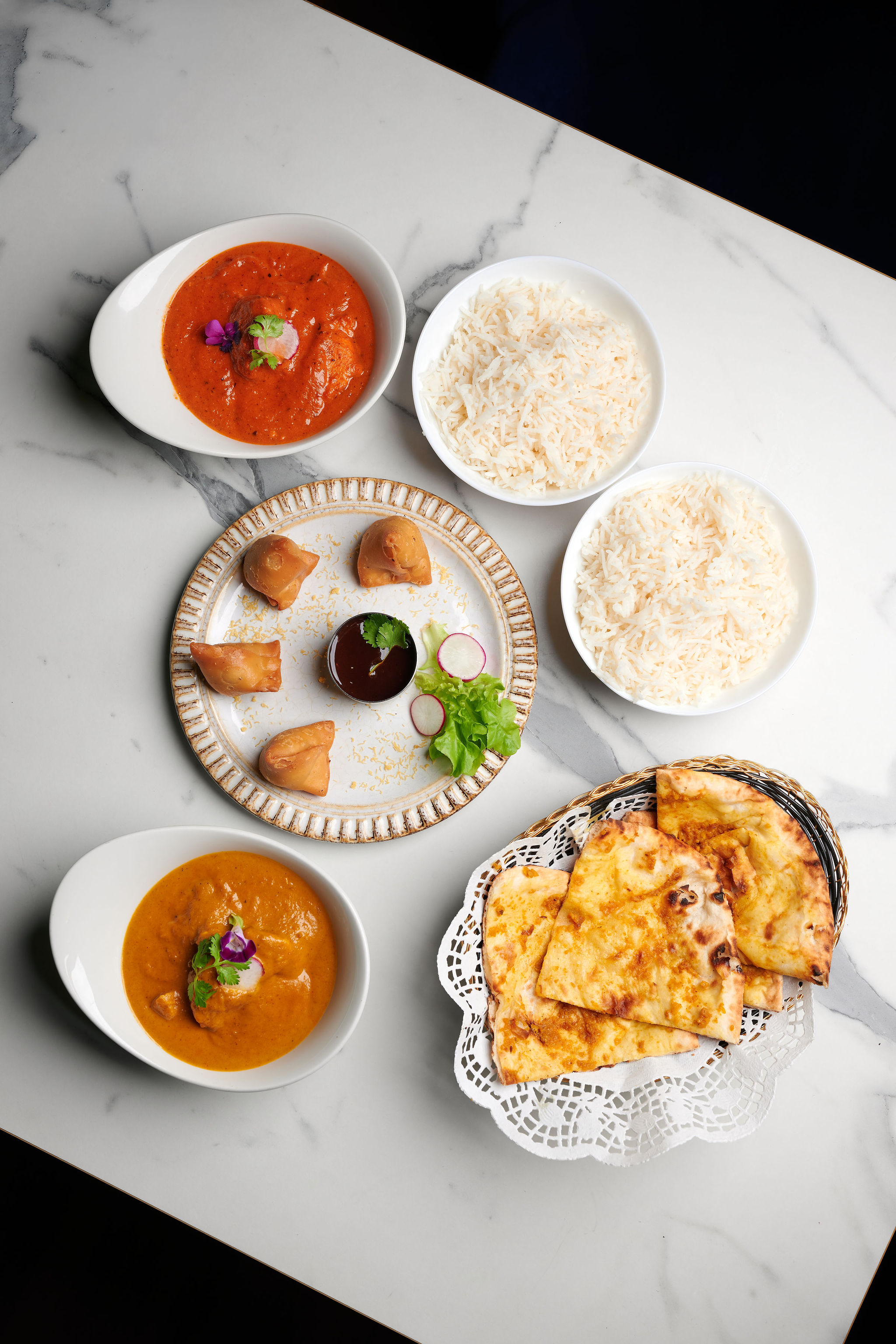 A plated Indian thali with curries, rice and sides